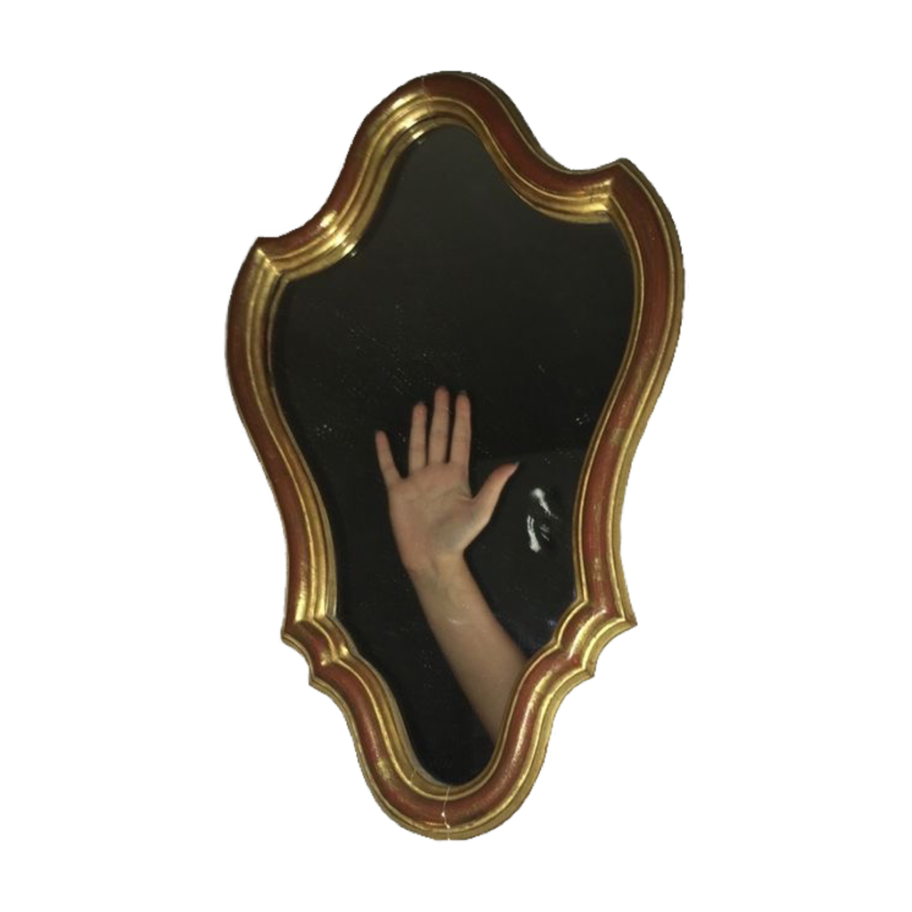 foto colorida de um espelho de moldura parecendo um brasão com o reflexo do braço de uma pessoa mostrando a palma da mão